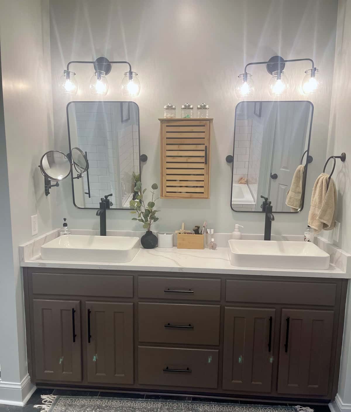 Charcoal shaker double vanity with white vessel sinks, matte black faucets, pivot mirrors and globe vanity lights