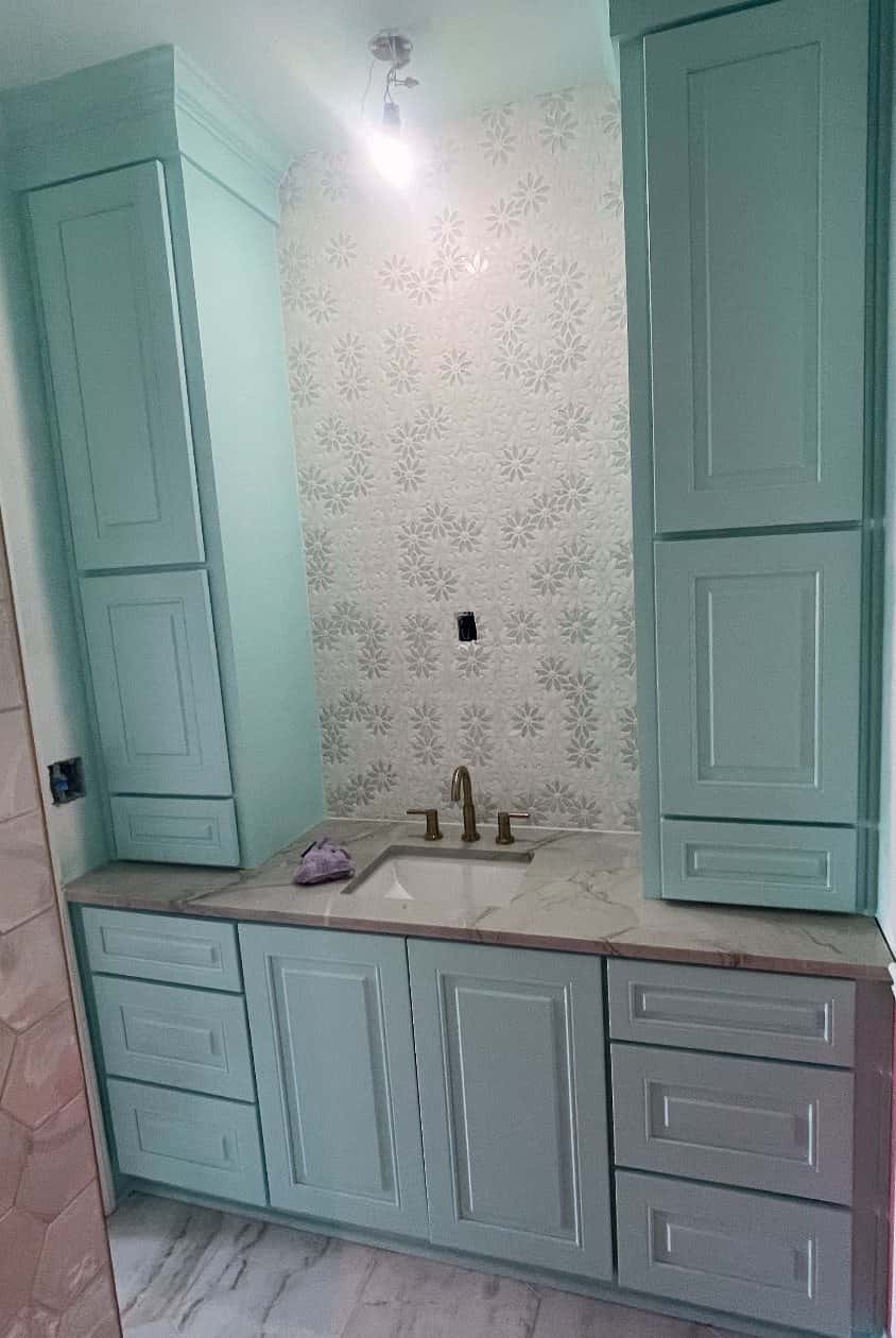Mint double-tower bathroom vanity with marble-look quartz top, brass faucet and floral mosaic tile feature wall